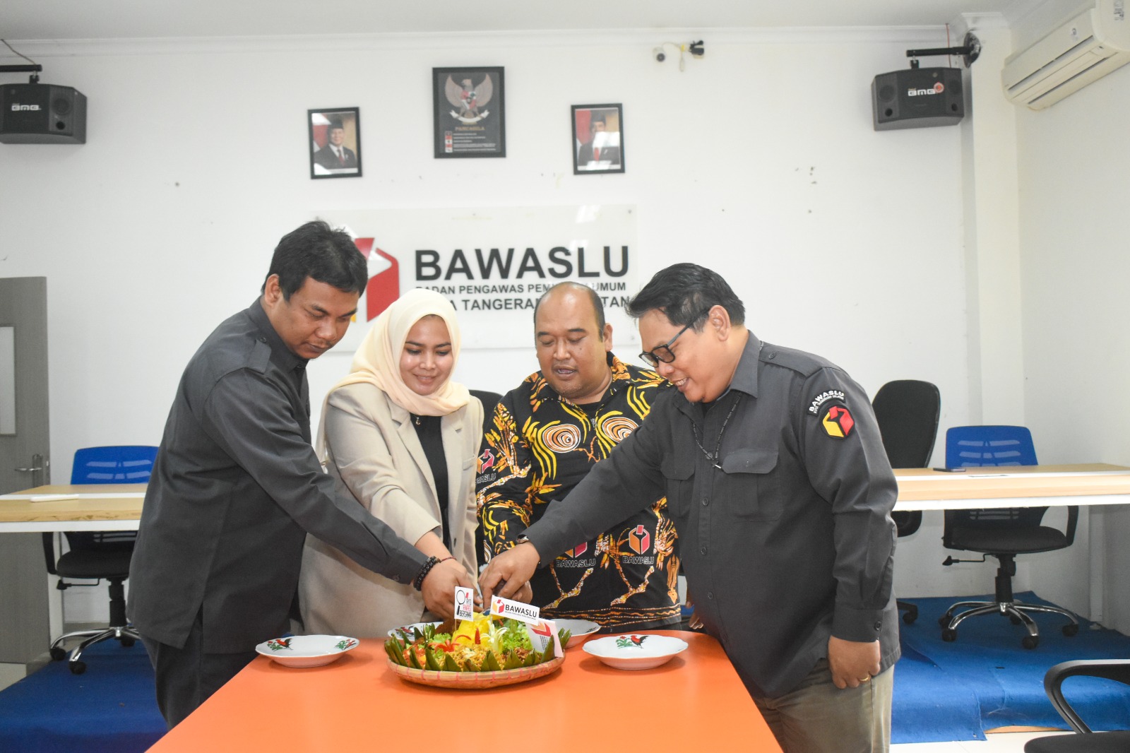 Ketua dan Anggota Bawalsu Kota Tangerang Selatan sedang memotong tumpeng memperingati HUT Bawaslu ke-17